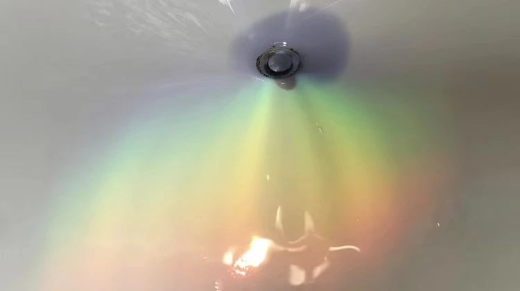 Rainbow-colored light fanning out across a pale surface