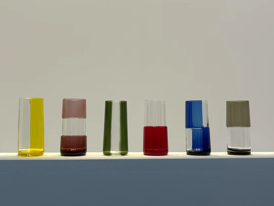 A row of colored glass vessels